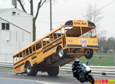1997 Ford Probe - A modified school bus performs a wheelie, with a motorcycle rider in close proximity on the track.