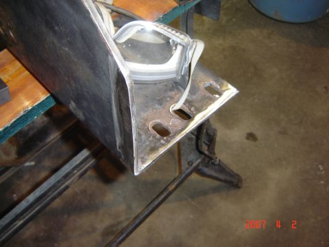 1993 Ford Bronco - A close-up view of a rusty metal car part, possibly a fender or bumper section, with safety glasses resting on it.
