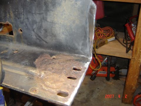 1993 Ford Bronco - A close-up view of a corroded metal bumper section, showing signs of wear and tear.