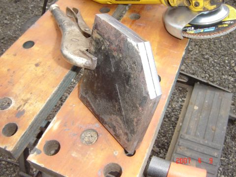 1993 Ford Bronco - A metal part is secured with vise grips on a workbench, with an angle grinder nearby.