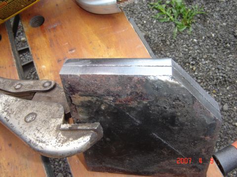 1993 Ford Bronco - A metal component, possibly a bumper section, is secured in a vise for work.