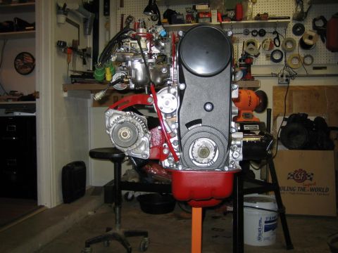 1987 Suzuki Samurai - An engine assembly is mounted on a stand in a workshop, with various tools and equipment in the background.