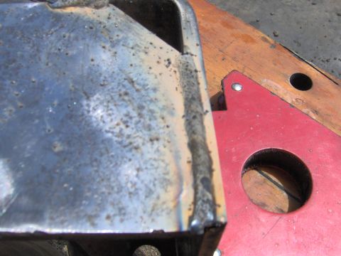 1993 Ford Bronco - A close-up view of a metal part with visible welds and rust, held by a magnetic clamp.