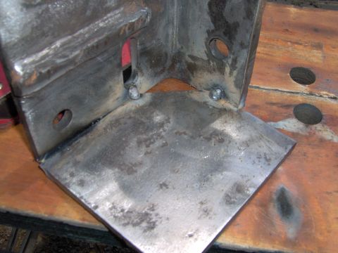 1993 Ford Bronco - A metal bracket, likely a custom part, is shown on a workbench.