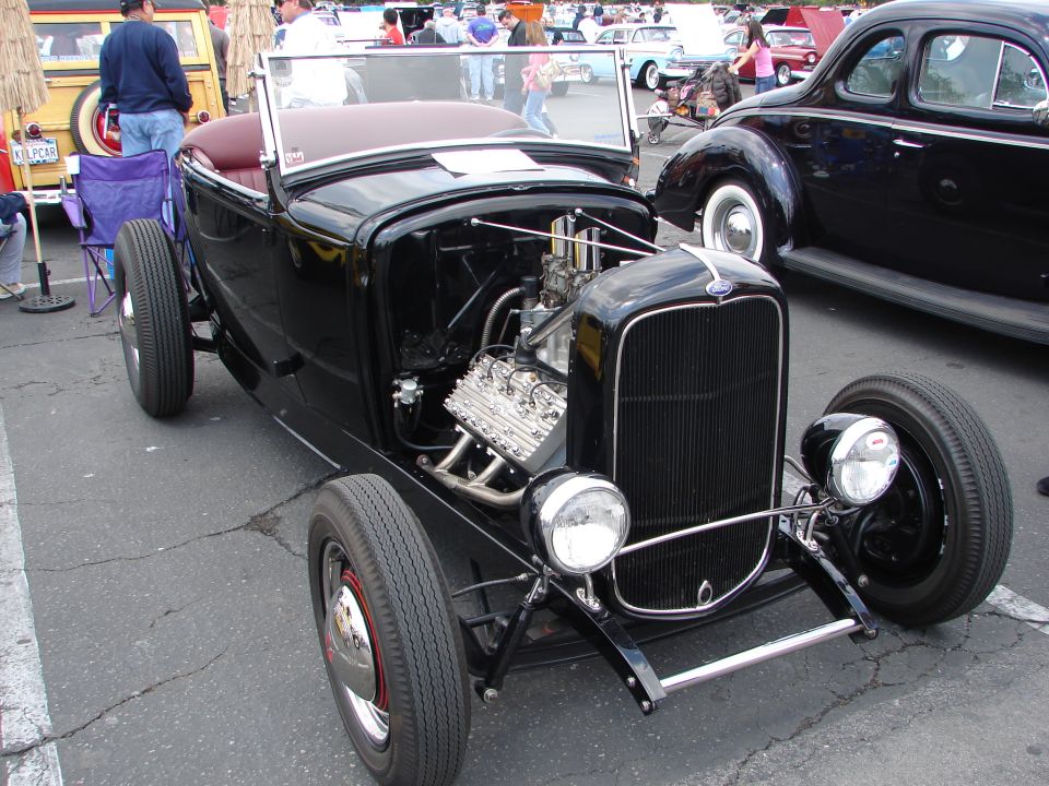 Black hot rod roadster, front view, exposed V8 engine