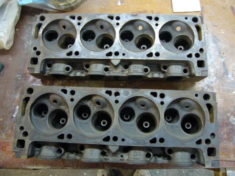 1972 Ford Ranchero - Two engine cylinder heads are shown from above, resting on a workbench.