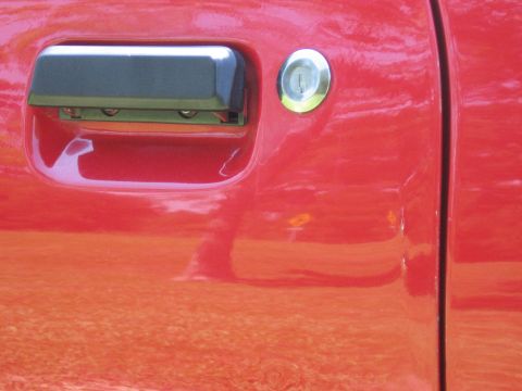 1967 Ford Mustang - The shiny red paint on the car door reflects the surroundings.