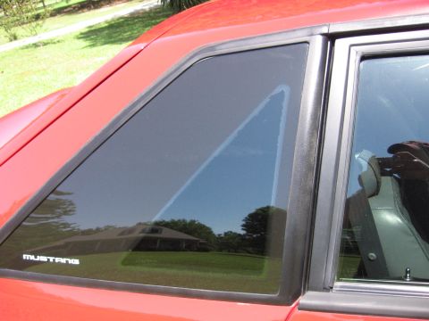 1967 Ford Mustang - Side view of a red car, a "Mustang" badge on the window trim.