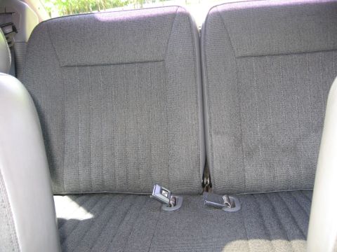1967 Ford Mustang - Interior view of a gray fabric rear seat with visible seatbelt buckles.