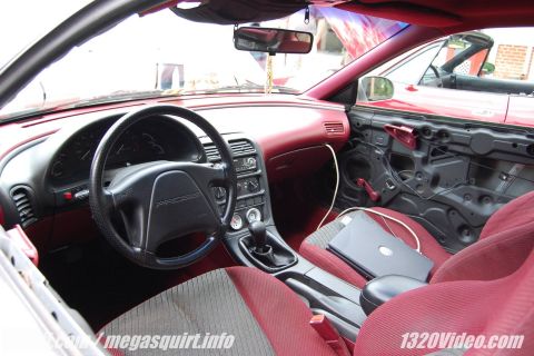 1993 Ford Probe - Interior view of a 1993 Ford Probe, showing red upholstery and a removed door panel. Another red car is visible outside.