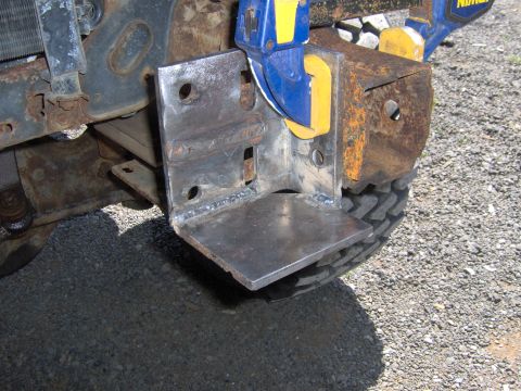 1993 Ford Bronco - A custom metal bracket is being attached to the frame of a vehicle.