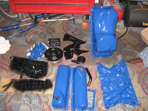 1979 Ford Bronco - Various engine components, painted blue, are arranged on a patterned carpet.