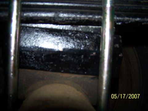 1979 Ford F-150 - A close-up view of a vehicle's suspension system, specifically the leaf spring and U-bolt assembly, with a tire in the background.