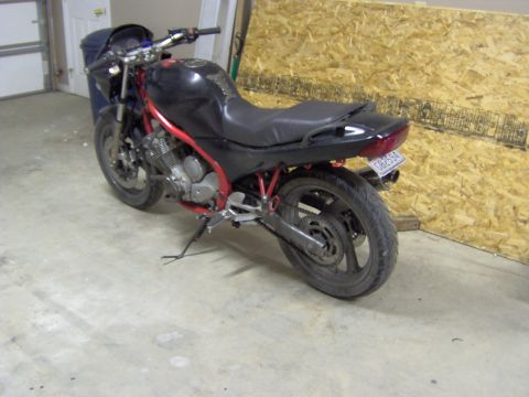 1993 Yamaha Seca II - A black motorcycle with a red frame is parked indoors, viewed from the rear three-quarter angle.