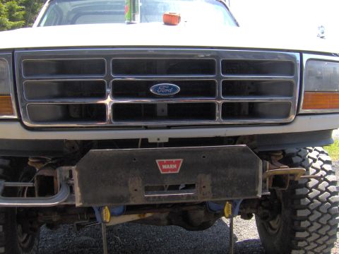 1993 Ford Bronco - Close-up of a Ford truck's front end, a prominent grille and a WARN winch attached to the bumper.