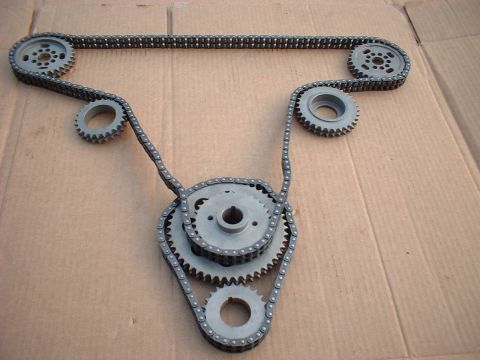 1964 Ford 427 - A set of engine timing chains and gears is displayed on a brown cardboard background.