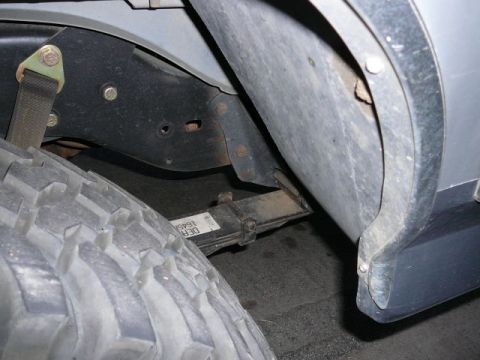 1988 Ford Bronco - Vehicle leaf spring and tire detail.