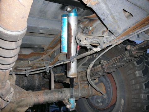 1988 Ford Bronco - Close-up of a vehicle's rear suspension system, including leaf springs and a shock absorber.