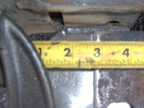 1993 Ford Bronco - A yellow measuring tape is placed against a metal component, indicating a measurement.