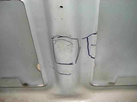 1997 Lincoln Town Car - The underside of a vehicle's hood shows markings drawn with a marker, possibly for repair or modification.