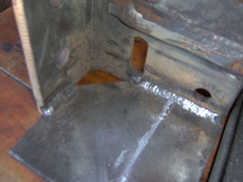 1993 Ford Bronco - Welded metal bracket with a triangular cut-out and visible weld seams.