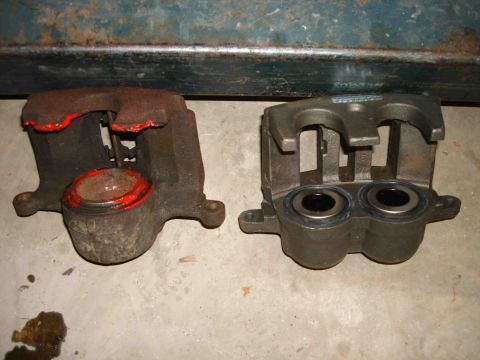 1997 Lincoln Town Car - Comparison of a used and a new brake caliper, highlighting wear and tear on the older part.