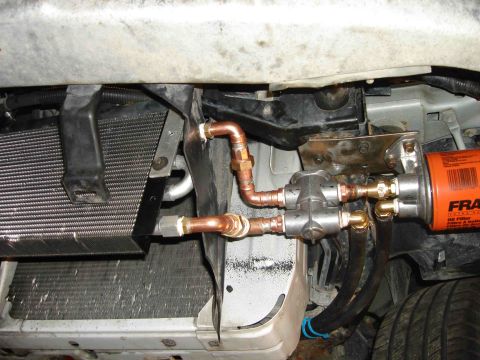 1997 Lincoln Town Car - Custom engine oil cooler and remote filter installation, copper plumbing and an orange Fram oil filter.
