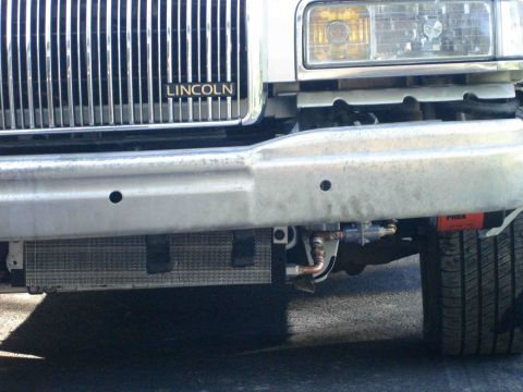 1997 Lincoln Town Car - The front of a Lincoln Town Car shows an aftermarket oil cooler installed below the bumper.