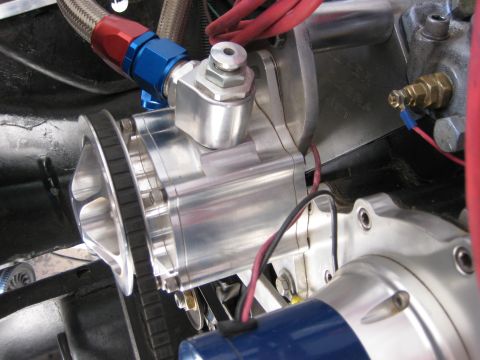 1979 Ford Bronco - Polished aluminum engine part with braided fuel line and drive belt visible.