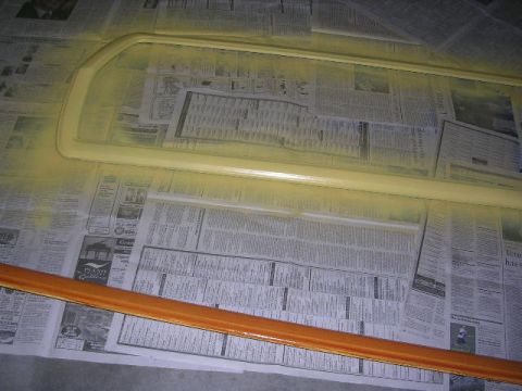 1975 Ford Ranchero - Car window trim and a wooden trim piece are laid out on newspaper, likely for painting or restoration.