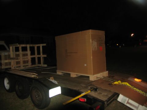 1988 Ford C-350 (Centurion Conversions) - A trailer is loaded with a large cardboard box and wooden crates at night.