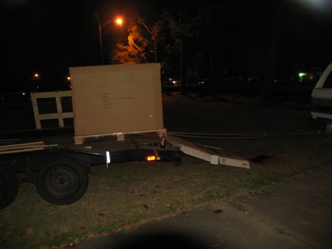 1988 Ford C-350 (Centurion Conversions) - Trailer loaded with a large box at night, with a van partially visible.