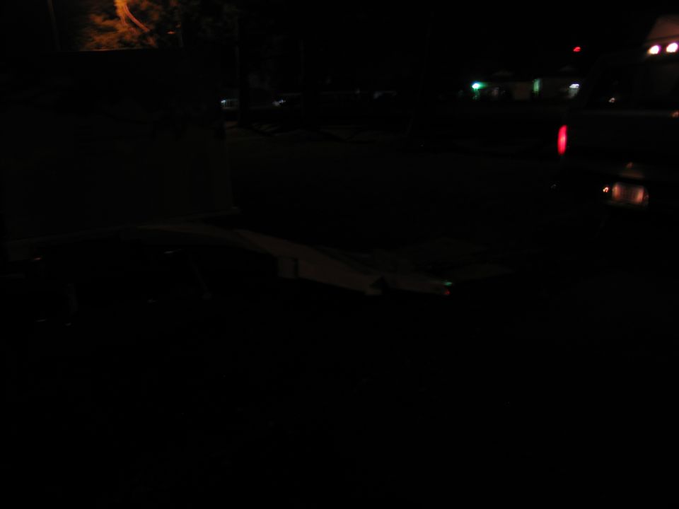 Dark photo of a truck bed with some items inside, viewed from above