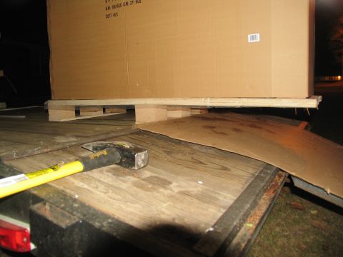 1988 Ford C-350 (Centurion Conversions) - A trailer bed holds a large cardboard box on a pallet, with a sledgehammer and ramp visible.