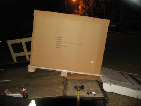 1988 Ford C-350 (Centurion Conversions) - A large cardboard box, labeled as a toolbox, sits on a trailer at night.