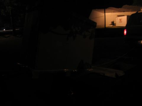 1988 Ford C-350 (Centurion Conversions) - A cargo box is loaded onto a trailer in the dark, with a vehicle nearby.