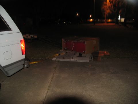 1988 Ford C-350 (Centurion Conversions) - Toolbox being unloaded from a vehicle using a ramp at night.