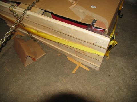 1988 Ford C-350 (Centurion Conversions) - A wooden crate secured with chains and straps is being moved.