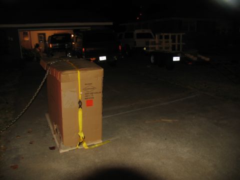 1988 Ford C-350 (Centurion Conversions) - A large box is prepared for transport, with several vehicles visible in the dimly lit background.