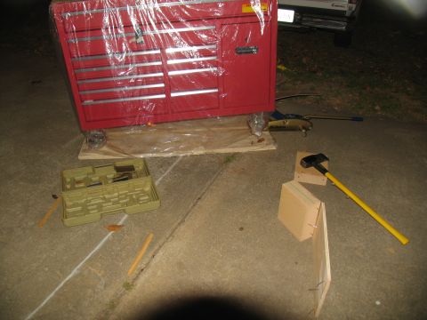 1988 Ford C-350 (Centurion Conversions) - A red toolbox is prepared for moving, with tools and a sledgehammer scattered around it on the ground.