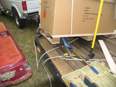 1988 Ford C-350 (Centurion Conversions) - A white Ford F-Series truck is parked next to a trailer loaded with a large box, secured by a cargo jack.