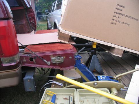 1988 Ford C-350 (Centurion Conversions) - Loading a large box into the cargo area of a van, with another van visible.
