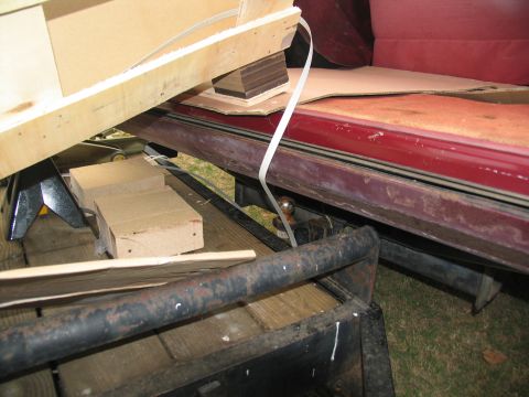 1988 Ford C-350 (Centurion Conversions) - A trailer hitch is visible on the rear of a red vehicle, with various items strapped down.