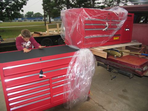 1988 Ford C-350 (Centurion Conversions) - Two large red toolboxes are on a trailer, one wrapped in plastic.