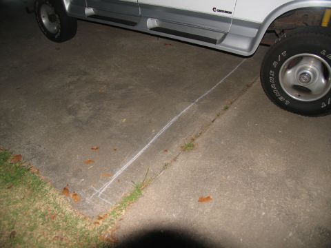 1988 Ford C-350 (Centurion Conversions) - A white van with silver trim and running boards is parked on a concrete surface, with chalk lines on the ground.
