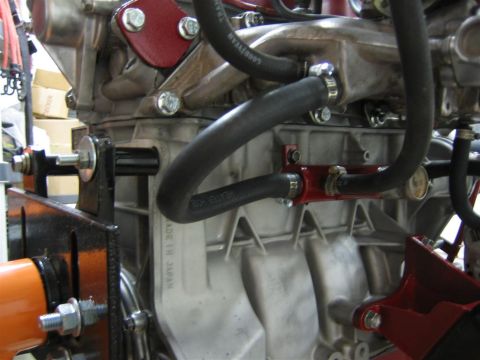 1987 Suzuki Samurai - Close-up of an engine block assembly, showing hoses and mounting hardware. Text indicates "MADE IN JAPAN".