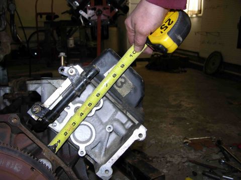 1997 Lincoln Town Car - A tape measure is used to measure an engine component in a workshop setting.
