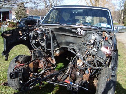 1995 Ford Bronco - Disassembled 1995 Ford Bronco engine bay, with a second Bronco visible in the background.