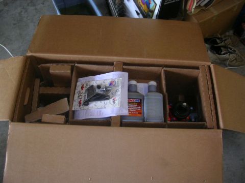 1975 Ford Ranchero - Contents of a box include a part and two bottles of Amsoil transmission fluid.