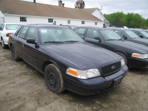 1991 Ford LTD Crown Victoria - A dark blue Ford Crown Victoria is parked in a lot, with other vehicles visible behind it.